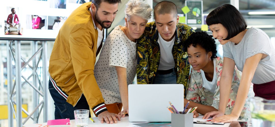 Front view of diverse business people discussing over laptop in the conference room at office